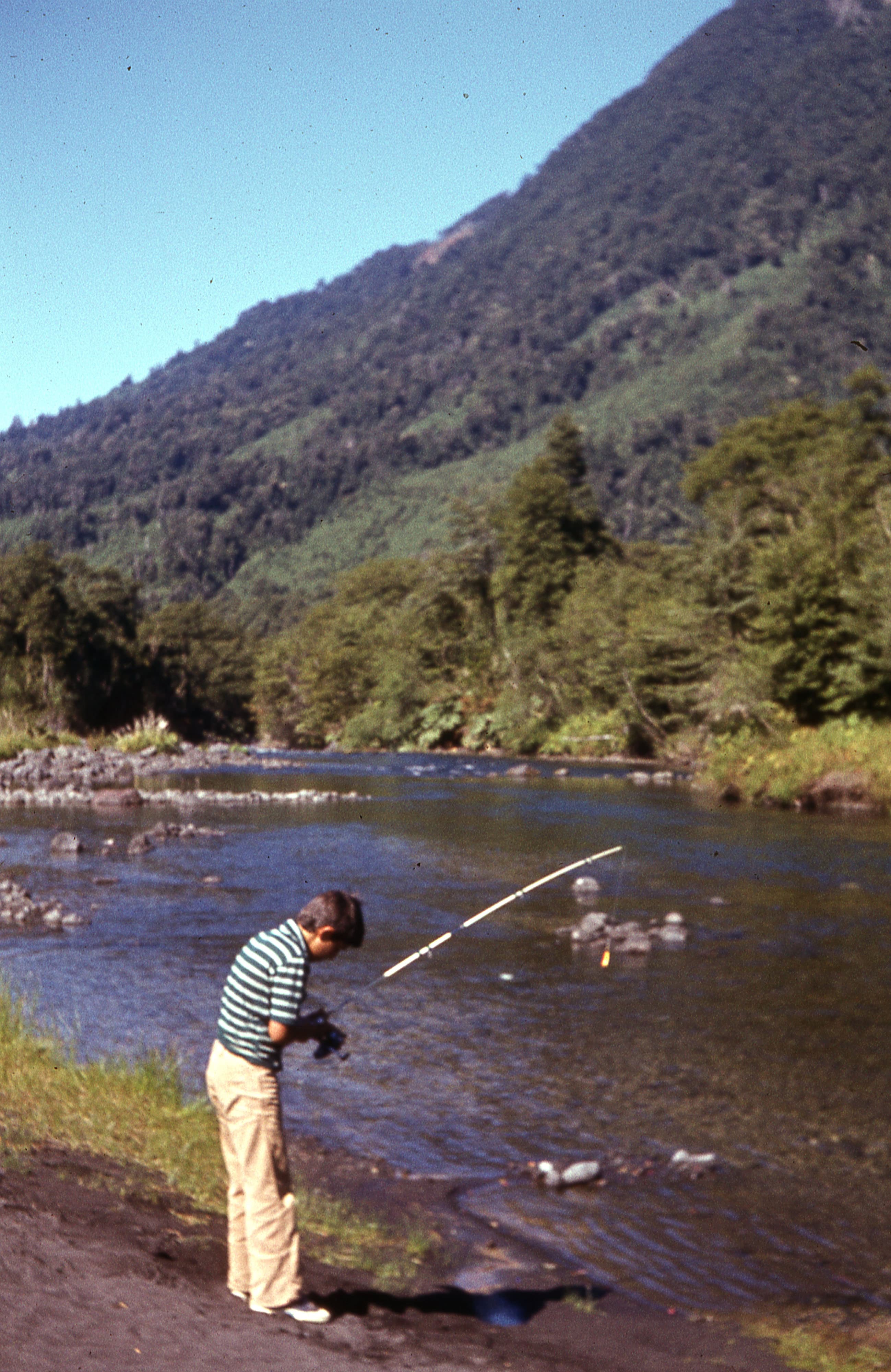 Hombre pescando en un río, ca. 1965