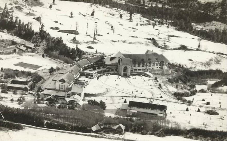 Gran vista aérea del Hotel Termas de Puyehue en 1954, bajo nieve.