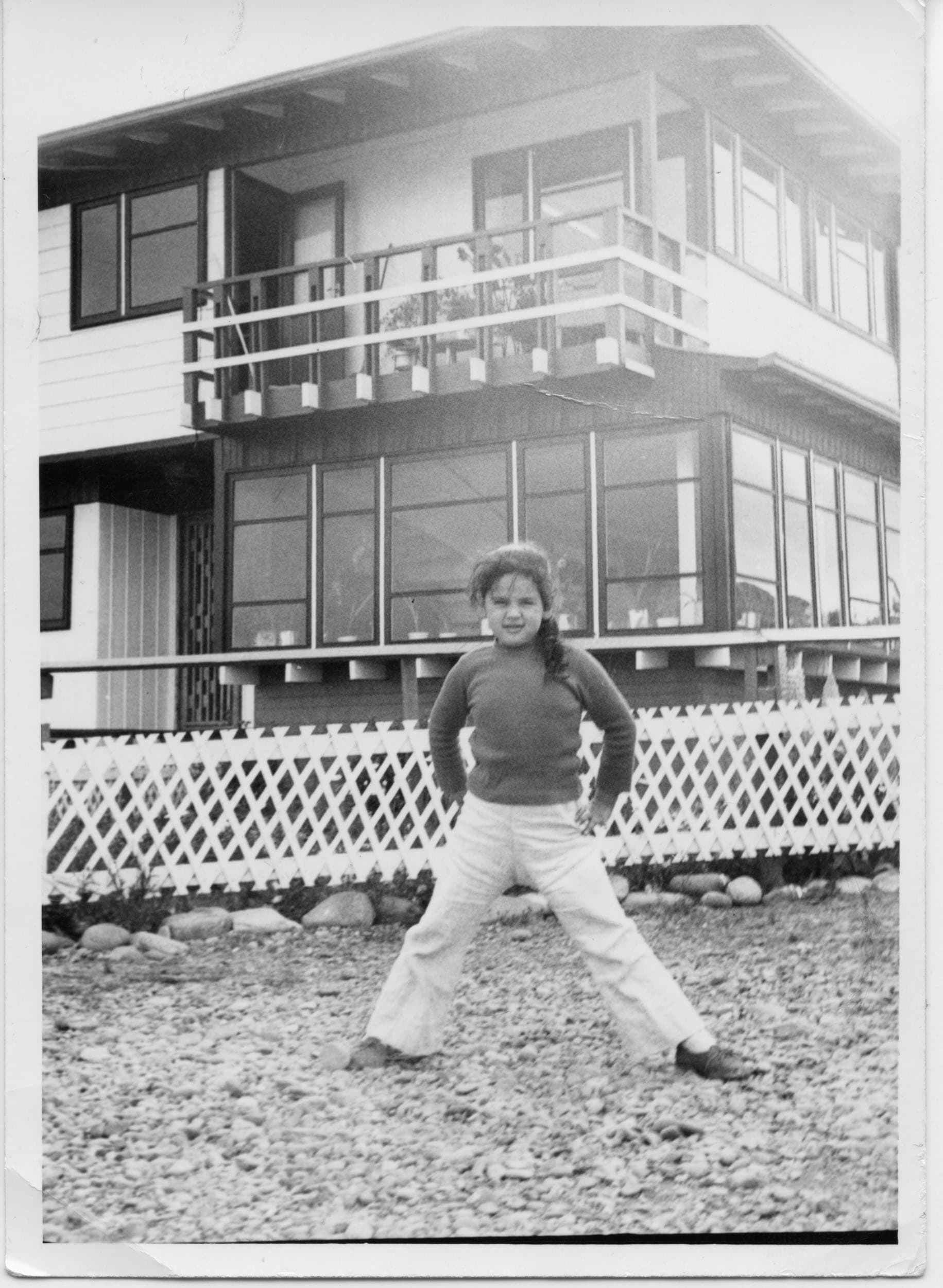 Niña posando frente a casa de dos pisos, Rey Don Felipe, ca. 1975