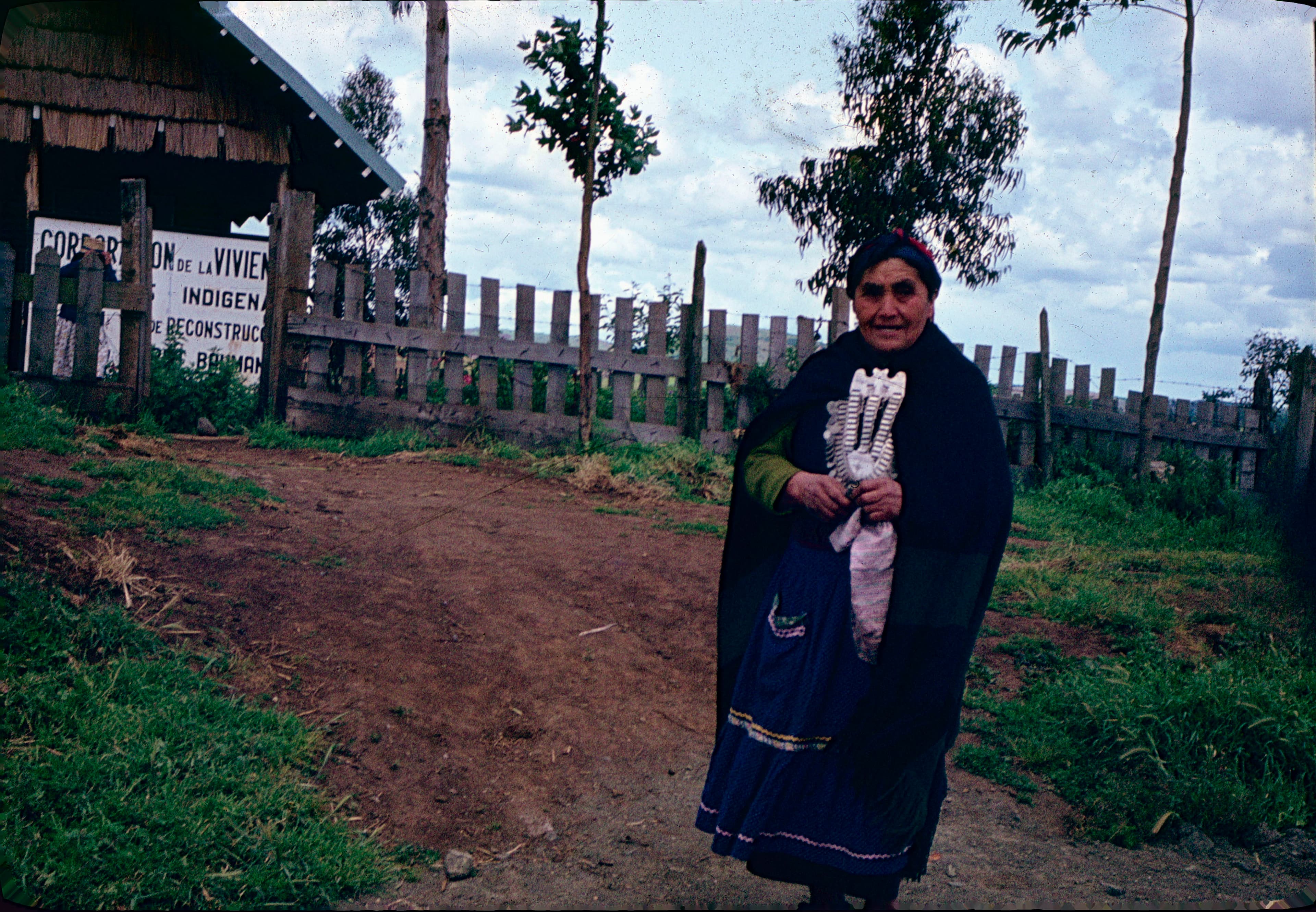 Mujer mapuche frente a letrero CORVI, ca. 1965