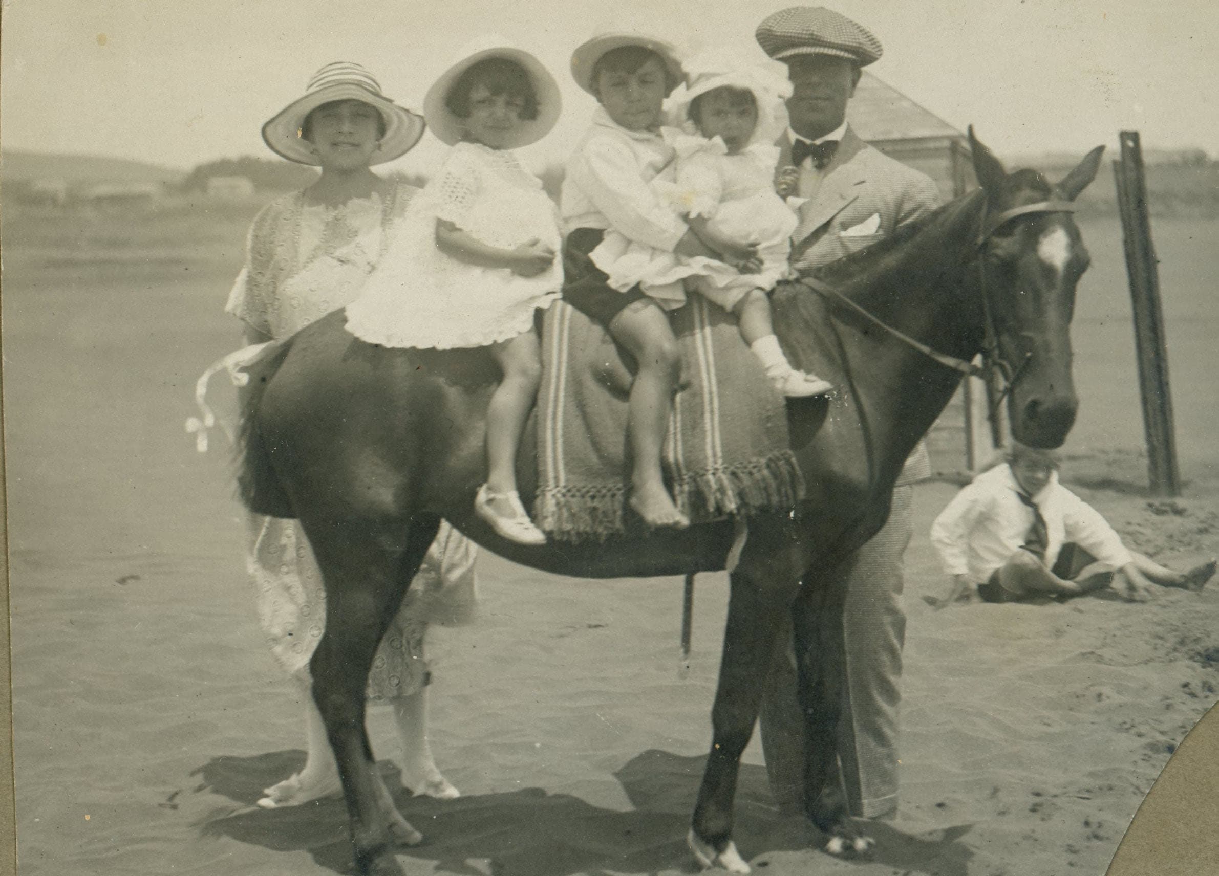 Familia y caballo en una playa, ca. 1920