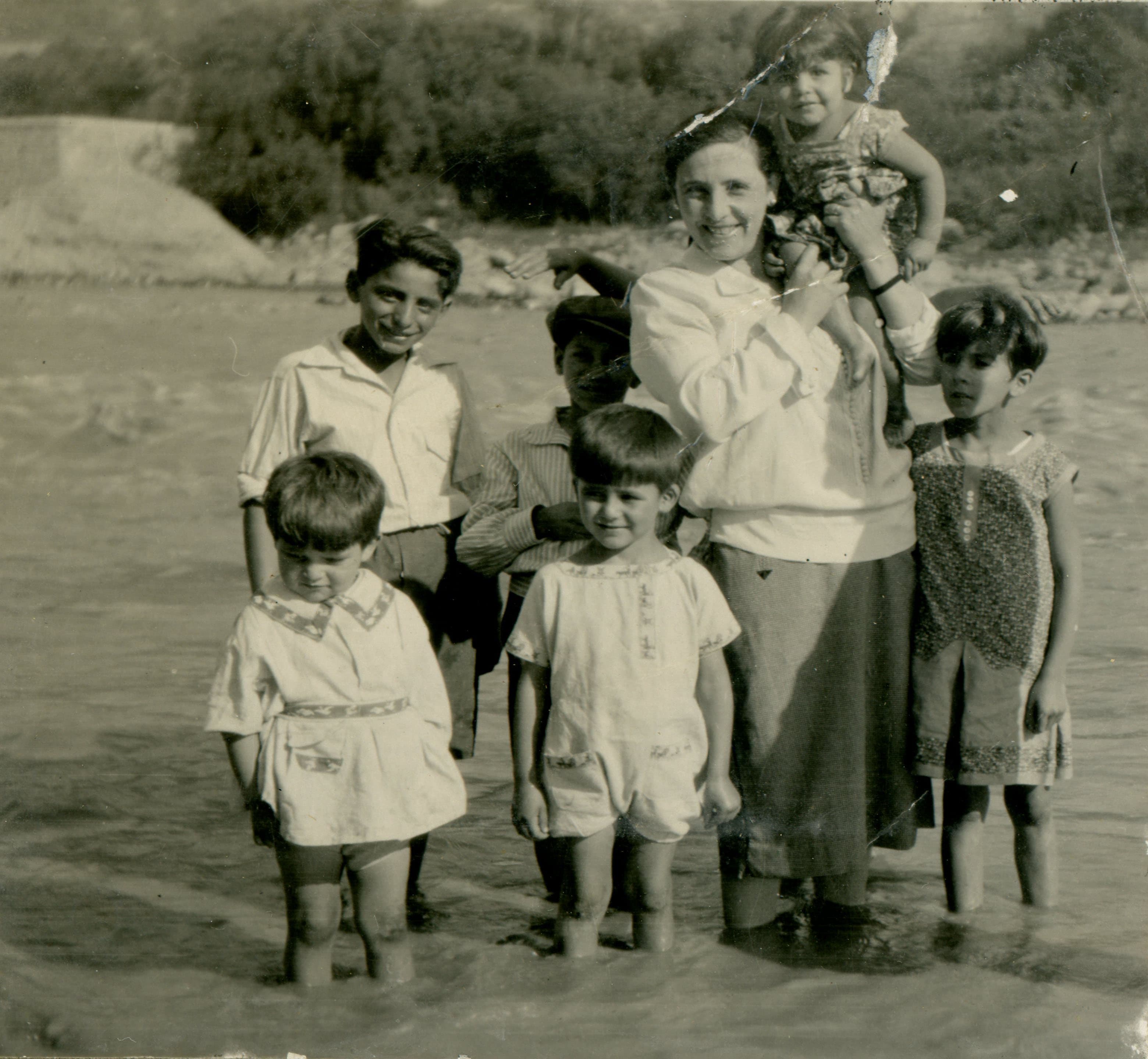 Mujer y niños en un río, sin lugar, ca. 1920