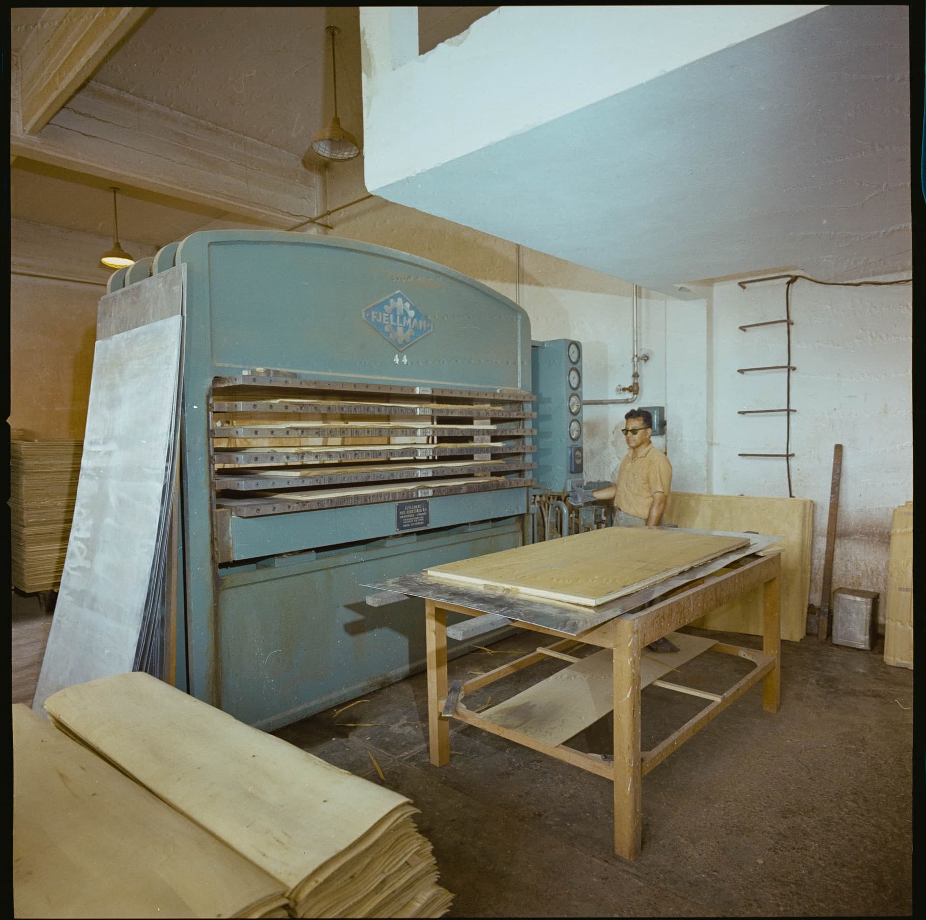 Hombre frente a una máquina que procesa madera, 1964